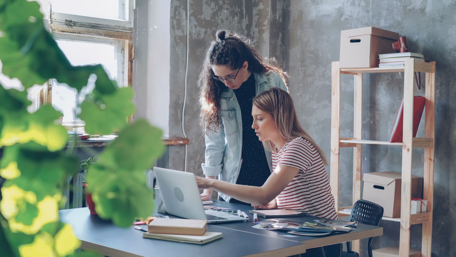 Deux collègues qui collaborent sur un ordinateur portable dans un bureau lumineux